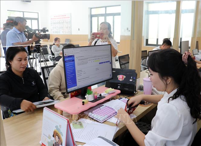 Cán bộ Trung tâm Phục vụ hành chính công phường Cam Ranh giải quyết các thủ tục hành chính cho người dân. Ảnh: Công Thử - TTXVN