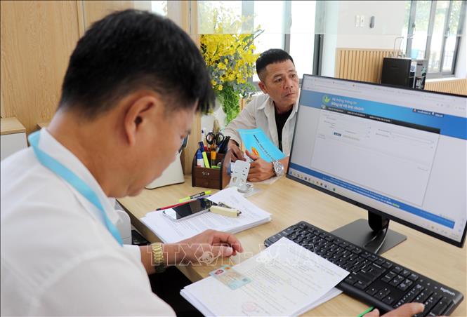 Cán bộ Trung tâm Phục vụ hành chính công phường Cam Ranh xử lý hồ sơ về đất đai cho người dân. Ảnh: Công Thử - TTXVN