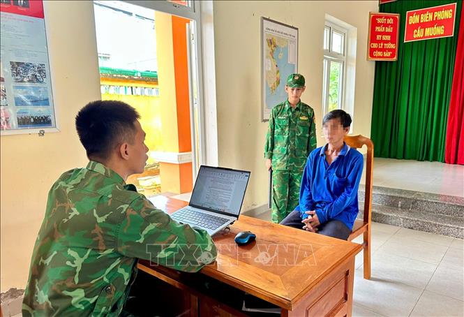 Cán bộ Biên phòng làm việc với đối tượng vận chuyển hàng hóa trái phép qua biên giới. Ảnh: TTXVN phát