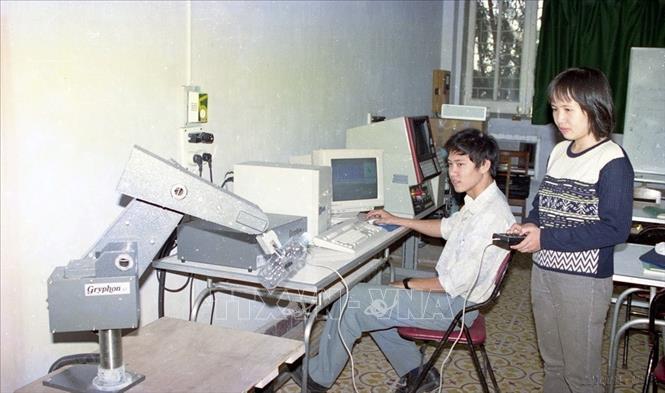 Sinh viên cao học khoa tự động hóa Đại học Bách khoa Hà Nội dùng rô bốt công nghiệp làm thí nghiệm (1998). Ảnh: Trí Dũng – TTXVN
