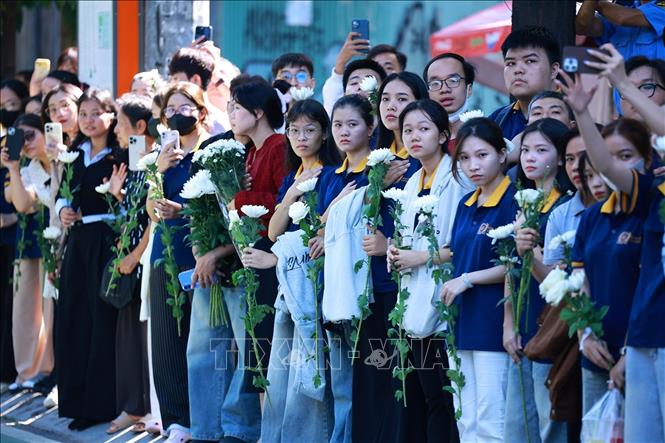 Đông đảo nhân dân Thành phố Hồ Chí Minh với nhành hoa trắng trên tay đưa tiễn hài cốt các Anh hùng liệt sĩ về Nghĩa trang liệt sĩ Thành phố Hồ Chí Minh. Ảnh: Dương Giang – TTXVN 
