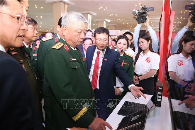 Thứ trưởng Bộ Quốc phòng Nguyễn Quang Ngọc cùng các đại biểu tham quan gian hàng của công ty Viettel. Ảnh: Minh Hưng - PV TTXVN tại Campuchia