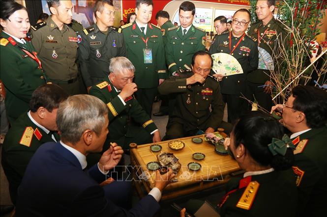 Thứ trưởng Nguyễn Quang Ngọc cùng Quốc vụ khanh Tan Thanna và các đại biểu thưởng thức trà và đồ ngọt Việt Nam tại hội chợ. Ảnh: Minh Hưng - PV TTXVN tại Campuchia