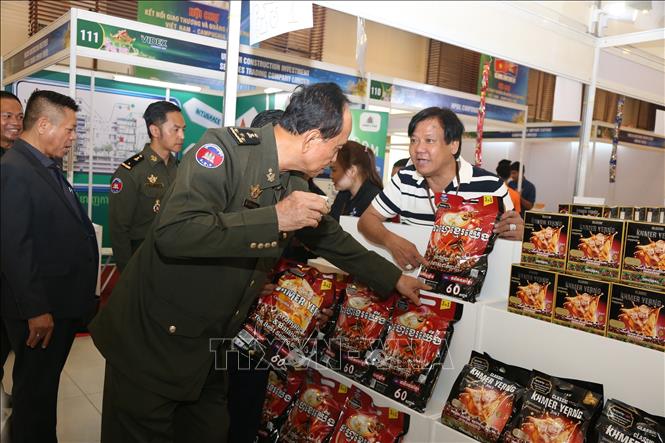 Quốc vụ khanh Bộ Quốc phòng Campuchia Tan Thanna tìm hiểu sản phẩm được trưng bày tại hội chợ. Ảnh: Minh Hưng - PV TTXVN tại Campuchia