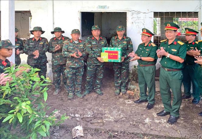Thiếu tướng Nguyễn Văn Ngành, Chỉ huy trưởng Bộ Chỉ huy Quân sự tỉnh Cà Mau thăm, tặng quà Đội tìm kiếm, quy tập hài cốt liệt sĩ (lâm thời) đang làm nhiệm vụ tại khu vực nghĩa trang tạm Cầu Chữ Y, thuộc ấp Cây Khô, xã Hồ Thị Kỷ, tỉnh Cà Mau. Ảnh: TTXVN phát