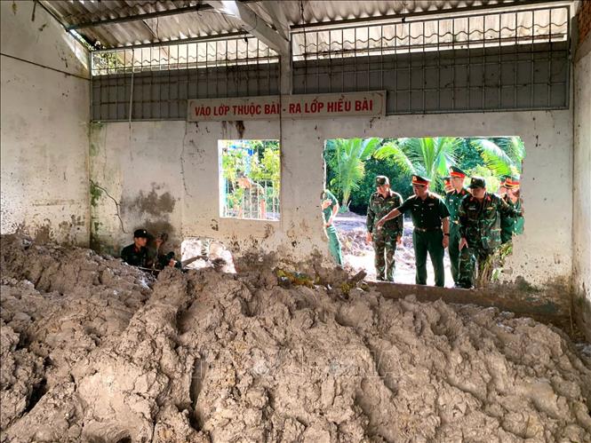 Thiếu tướng Nguyễn Văn Ngành, Chỉ huy trưởng Bộ Chỉ huy Quân sự tỉnh Cà Mau cùng đoàn công tác khảo sát tại khu vực đang tổ chức tìm kiếm, quy tập hài cốt liệt sĩ. Ảnh: TTXVN phát