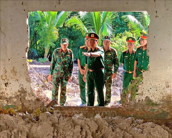 Thiếu tướng Nguyễn Văn Ngành, Chỉ huy trưởng Bộ Chỉ huy Quân sự tỉnh Cà Mau, cùng đoàn công tác khảo sát tại khu vực đang tổ chức tìm kiếm, quy tập hài cốt liệt sĩ. Ảnh: TTXVN phát