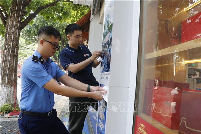 Lực lượng chức năng yêu cầu các cơ sở gỡ bỏ các biển hiệu chưa phù hợp tại phường Kinh Bắc, thành phố Bắc Ninh. Ảnh: Thái Hùng - TTXVN
