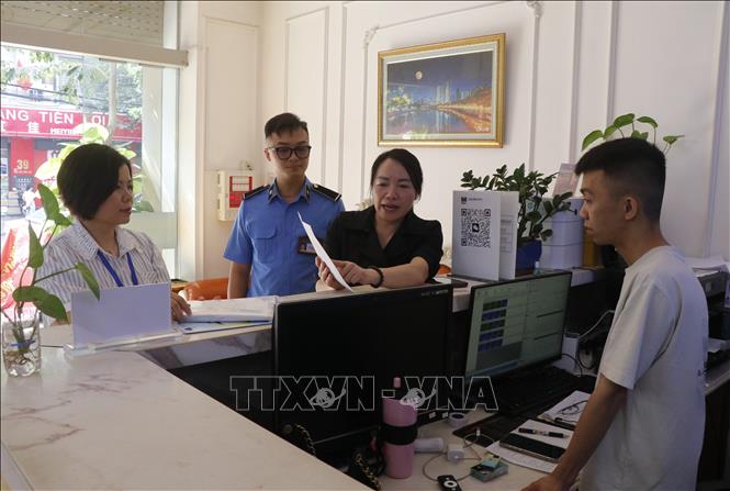Phường Kinh Bắc tuyên truyền các cơ sở kinh doanh chấp hành nghiêm các quy định về biển hiệu, quảng cáo. Ảnh: Thái Hùng - TTXVN