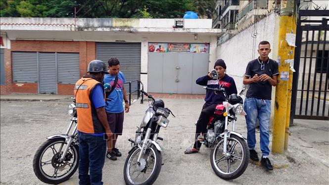 Thanh niên hành nghề xe ôm tại thủ đô Caracas, Venezuela. Ảnh: Phi Hùng - PV TTXVN tại Mỹ Latinh
