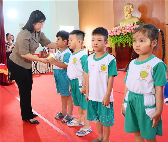 Bà Nguyễn Hoàng Uyên, Phó Giám đốc Sở Y tế Tây Ninh trao quà, động viên các em học sinh có hoàn cảnh khó khăn tại chương trình chăm lo an sinh xã hội. Ảnh: Thanh Bình -TTXVN