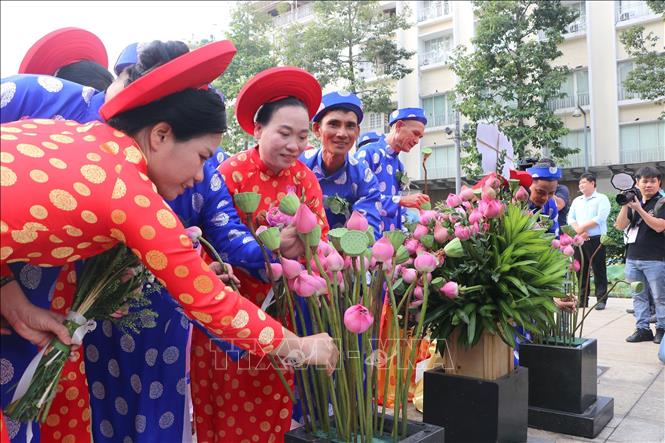 Các cặp đôi là đoàn viên Công đoàn, hội viên, thanh niên công nhân, viên chức, người lao động dâng hoa Chủ tịch Hồ Chí Minh tại Công viên Tượng đài Bác Hồ (phố đi bộ Nguyễn Huệ). Ảnh: Thanh Vũ - TTXVN