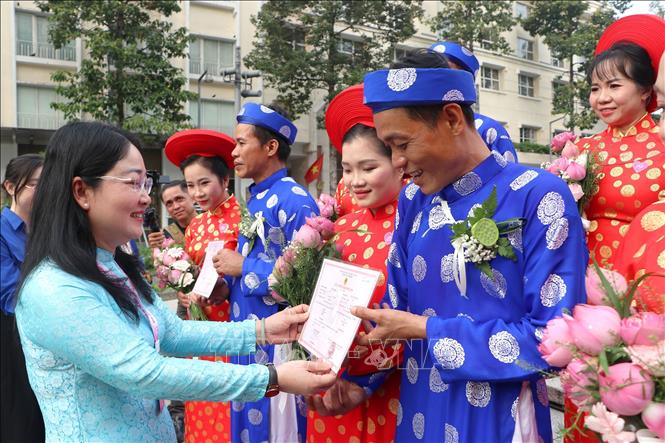 Phó Chủ tịch LĐLĐ TP. Hồ Chí Minh Nguyễn Kim Loan trao giấy đăng ký kết hôn cho các cặp đôi là đoàn viên Công đoàn, hội viên, thanh niên công nhân, viên chức, người lao động tham gia “Lễ cưới tập thể” năm 2026. Ảnh: Thanh Vũ – TTXVN