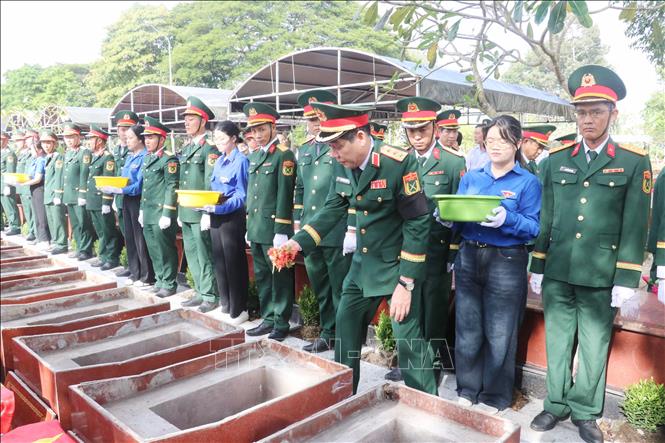 Thượng tướng Nguyễn Văn Gấu thực hiện nghi thức an táng hài cốt liệt sĩ. Ảnh: Ngọc Thiện - TTXVN