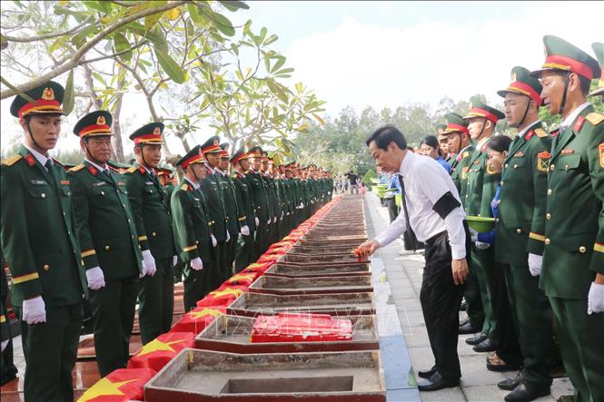 Ông Đỗ Thanh Bình, Ủy viên BCH Trung ương, Bí thư Thành ủy Cần Thơ thực hiện nghi thức an táng hài cốt liệt sĩ. Ảnh: Ngọc Thiện - TTXVN