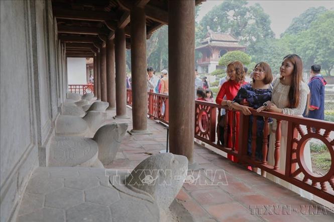 Du khách thăm quan khu bia tiến sĩ tại Văn Miếu - Quốc Tử Giám. Ảnh: Lê Đông - TTXVN