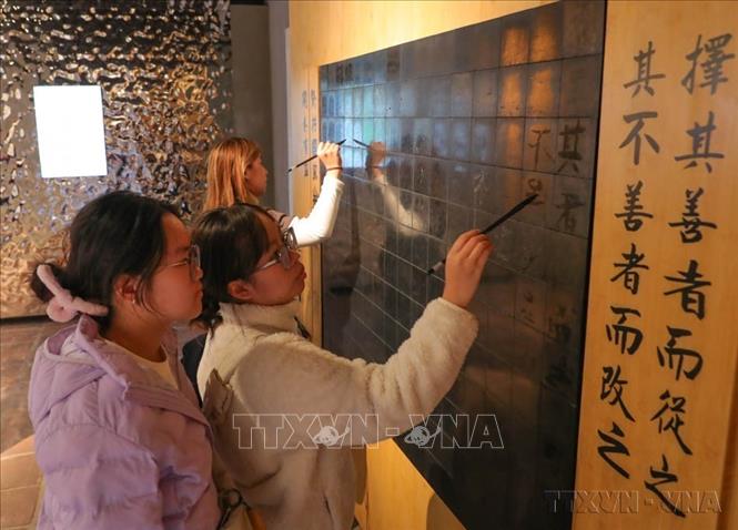 Du khách tham gia hoạt động trải nghiệm tại Văn Miếu-Quốc Tử Giám. Ảnh: Hoàng Hiếu - TTXVN