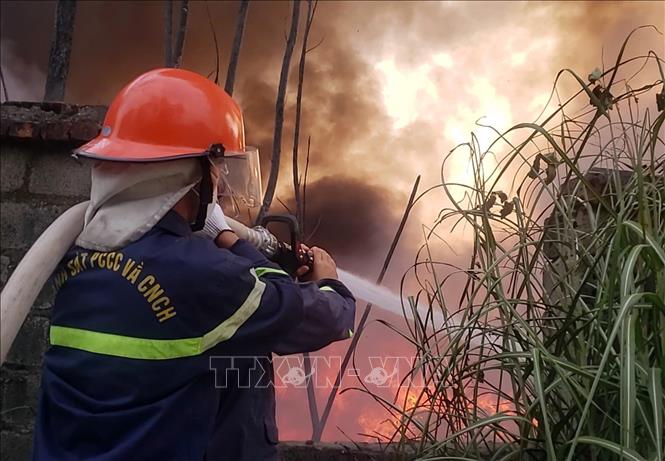 Lực lượng cứu hỏa khẩn trương tiếp cận hiện trường vụ cháy xưởng phế liệu ở xã Hội Thịnh. Ảnh: Hoàng Hùng - TTXVN