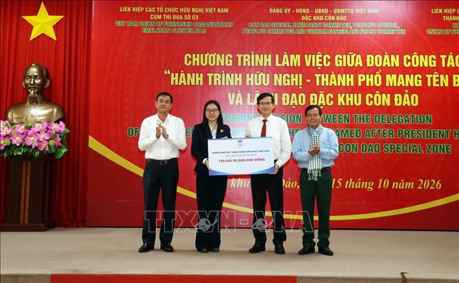 Bà Hà Thanh, Chủ tịch Liên hiệp các tổ chức hữu nghị Thành phố Hồ Chí Minh trao bảng tượng trưng tặng học bổng cho các học sinh Côn Đảo. Ảnh: Xuân Khu - TTXVN 