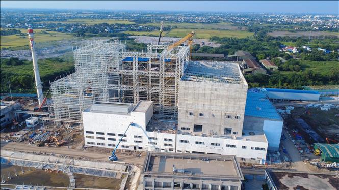 Nhà thầu huy động máy móc, nhân lực thi công, sớm đưa nhà máy vào hoạt động để xử lý lượng rác thải tồn đọng tại các bãi chôn lấp. Ảnh: Công Luật - TTXVN