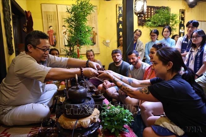 Dưới bàn tay khéo léo của nghệ nhân trà Nguyễn Cao Sơn tại Ngôi nhà di sản (số 87 Mã Mây, Hoàn Kiếm, Hà Nội), những người yêu mến trà và du khách nước ngoài được thưởng thức, tìm hiểu về trà trong không gian ấm cúng, gần gũi, đậm chất Thủ đô. Ảnh: Minh Đức – TTXVN