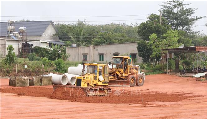 Máy san gạt đất, tạo mặt bằng phục vụ thi công các hạng mục đường giao thông kết nối Khu công nghiệp và dân cư Đồng Phú. Ảnh: Đậu Tất Thành - TTXVN