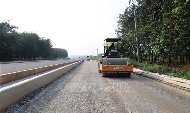 Công nhân vận hành xe lu hoàn thiện nền đường trên tuyến số 4, góp phần đẩy nhanh tiến độ thi công công trình giao thông kết nối tại phường Đồng Phú. Ảnh: Đậu Tất Thành - TTXVN