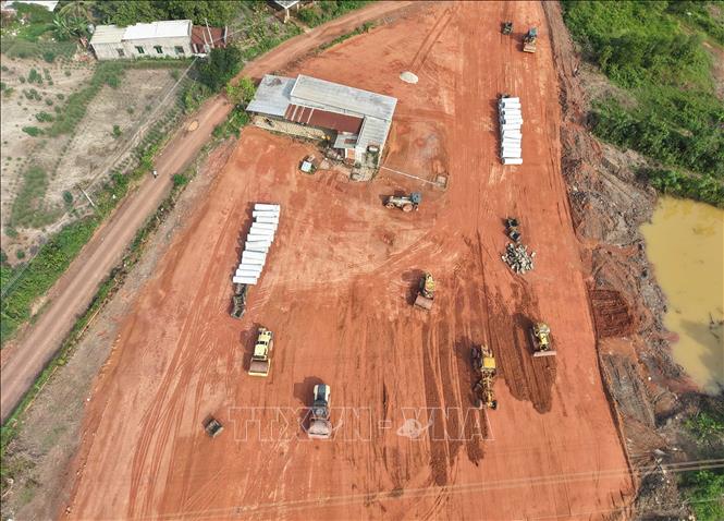 Máy móc được huy động san gạt, lu lèn nền đường tại công trình giao thông kết nối Khu công nghiệp và dân cư Đồng Phú. Ảnh: Đậu Tất Thành - TTXVN 