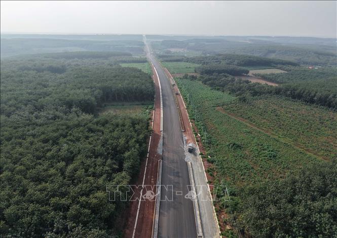 Toàn cảnh tuyến đường số 4 nhìn từ trên cao, kéo dài giữa những vùng rừng trồng và đất sản xuất tại phường Đồng Phú, góp phần tăng cường kết nối giao thông khu vực. Ảnh: Đậu Tất Thành - TTXVN 
