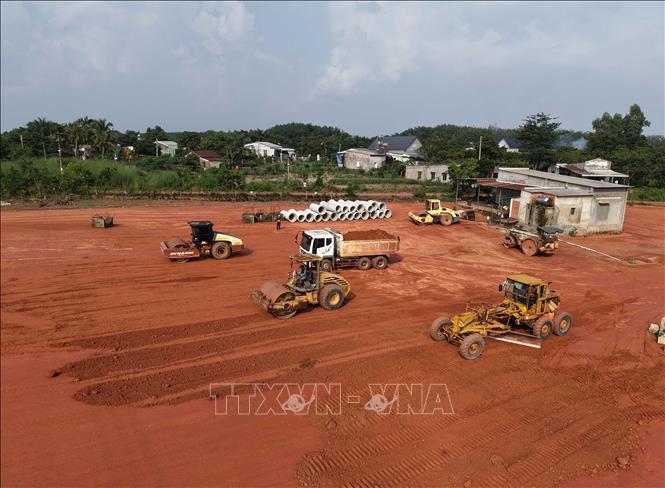 Xe lu, xe ben và máy san hoạt động liên tục trên công trường, tranh thủ thời tiết thuận lợi để đẩy nhanh tiến độ thi công. Ảnh: Đậu Tất Thành - TTXVN