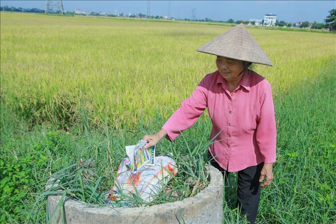 Nông dân xã Nam Minh bỏ vỏ bao bì thuốc bảo vệ thực vật sau sử dụng vào đúng nơi quy định. Ảnh: Công Luật - TTXVN