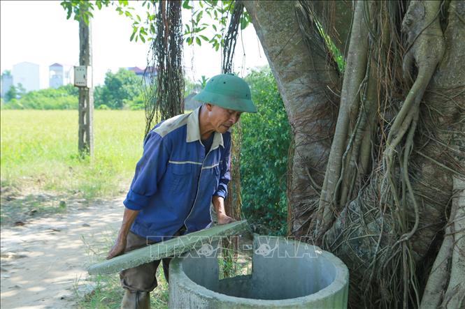 Cán bộ Hội nông dân phường Hồng Quang kiểm tra bể chứa vỏ bao bì thuốc bảo vệ thực vật để thu gom xử lý theo quy định. Ảnh: Công Luật - TTXVN