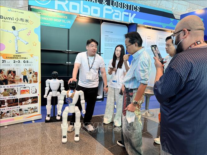 Khách tham quan triển lãm thử nghiệm giao lưu với robot. Ảnh: Lê Anh - PV TTXVN tại Hong Kong (Trung Quốc)