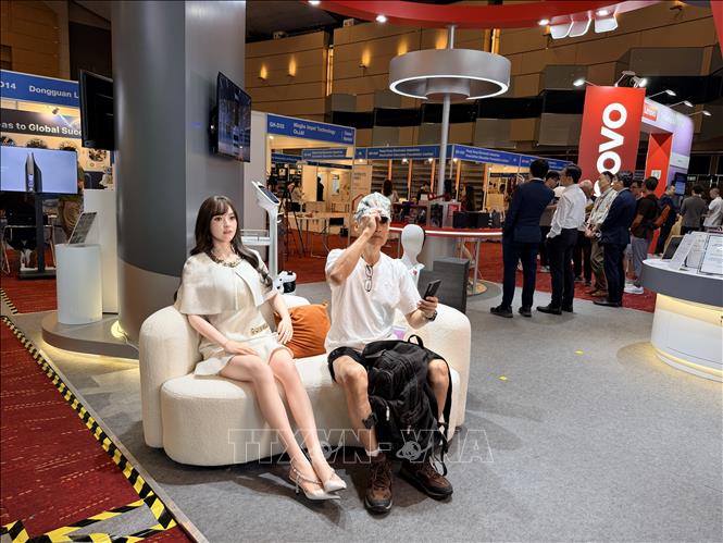 Khách tham quan triển lãm thử nghiệm giao lưu với robot. Ảnh: Lê Anh - PV TTXVN tại Hong Kong (Trung Quốc)