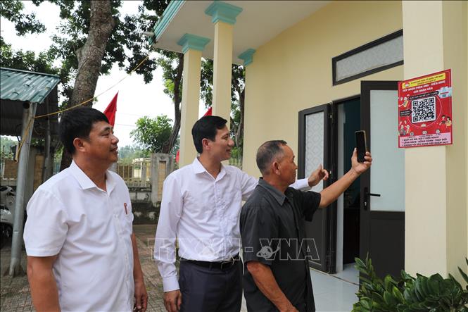 Cán bộ Ủy ban MTTQ phường Đào Duy Từ hướng dẫn người dân quét mã QR- Lắng nghe ý kiến nhân dân. Ảnh: Khiếu Tư - TTXVN