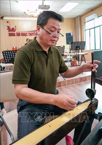 NSƯT Đăng Dương không chỉ nổi tiếng với giọng hát thính phòng và nhạc cách mạng mà còn từng có nhiều năm gắn bó, học tập chuyên ngành đàn bầu tại Học viện Âm nhạc Quốc gia Việt Nam. Ảnh: Khánh Hoà - TTXVN