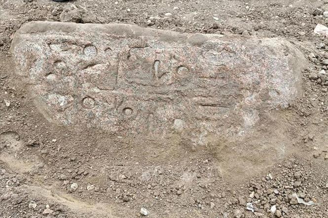 Khối đá granite màu hồng, dài khoảng 1,30 mét, có khắc các tước hiệu bằng chữ tượng hình của Ramesses II. Khối đá này được tìm thấy gần bức tượng thứ hai tại di chỉ Behbeit El-Hagar. Ảnh: TTXVN phát
