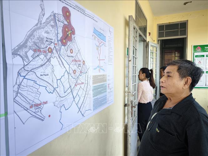 Ông Nguyễn Văn Minh, xã Đồng Khởi, tỉnh Vĩnh Long theo dõi bản đồ quy hoạch  mới khu Di tích quốc gia đặc biệt Đồng Khởi Bến Tre. Ảnh: Huỳnh Phúc Hậu - TTXVN