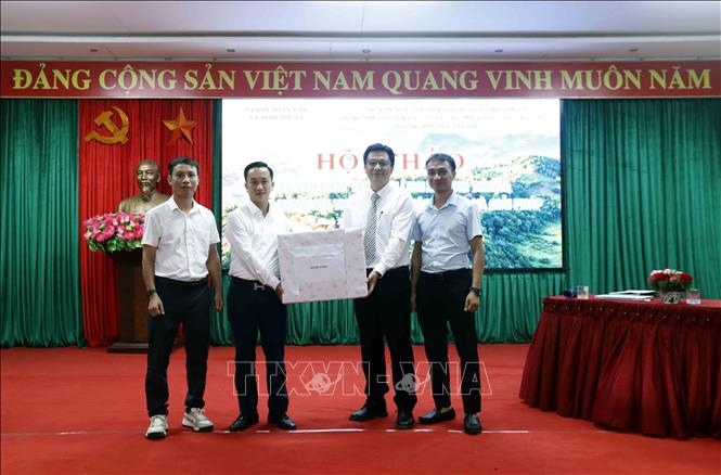 Đại diện Công ty CP cà phê DETECH Sơn La tặng quà cho xã Bình Thuận. Ảnh: Quang Quyết - TTXVN