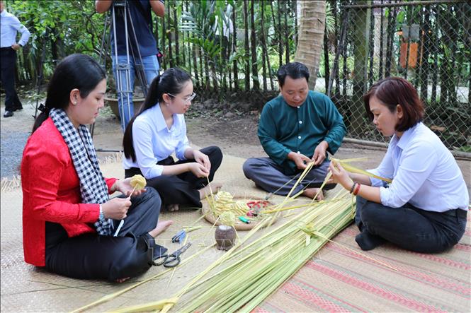 Khách trải nghiệm thắt lá dừa tại Trạm ký ức Trang Hòa, Làng du lịch cộng đồng Nhị Hòa. Ảnh: Thanh Hòa- TTXVN