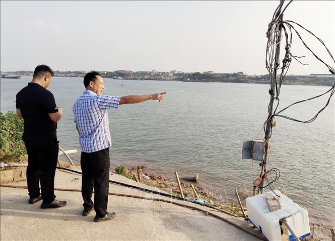 Bước đầu sạt lở làm hư hại một phần tuyến đường bê tông ra sông Hồng và diện tích đất nông nghiệp. Ảnh Mạnh Khánh/TTXVN 