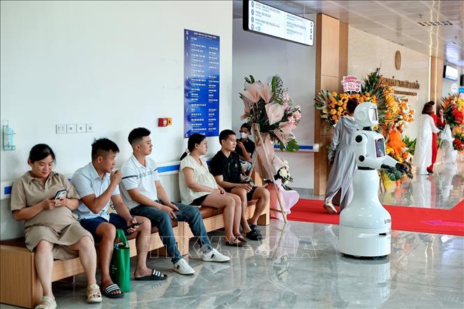 Người bệnh và người nhà chờ khám tại khu vực sảnh Bệnh viện Phụ sản Trung ương cơ sở 2, nơi bố trí robot hỗ trợ tra cứu thông tin và chỉ dẫn. Ảnh: Phạm Tuấn Anh - TTXVN