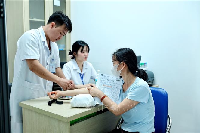 Nhân viên y tế thực hiện lấy mẫu máu xét nghiệm cho người bệnh tại Bệnh viện Phụ sản Trung ương cơ sở 2. Ảnh: Phạm Tuấn Anh - TTXVN