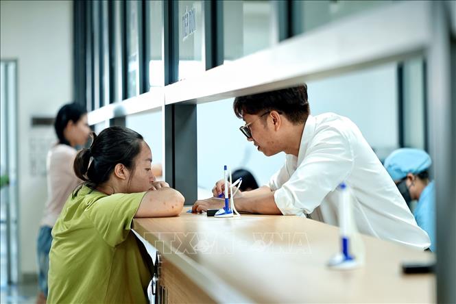 Nhân viên y tế hướng dẫn, tiếp nhận và hoàn thiện thủ tục đăng ký khám chữa bệnh cho người dân tại Bệnh viện Phụ sản Trung ương cơ sở 2. Ảnh: Phạm Tuấn Anh - TTXVN