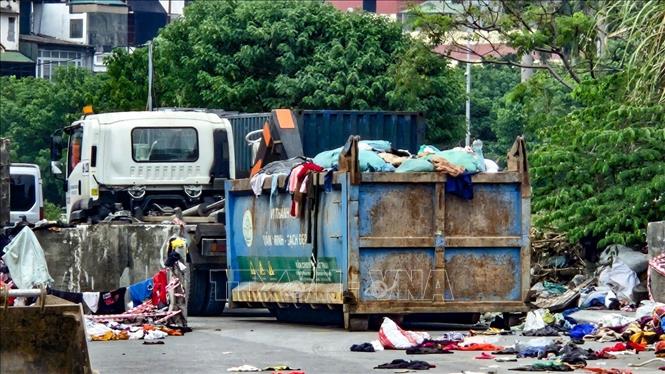 Quần áo cũ bị đổ bỏ ngổn ngang tại khu vực ngõ 252 Mỹ Đình, phường Từ Liêm (Hà Nội). Ảnh: Trung Nguyên - TTXVN.