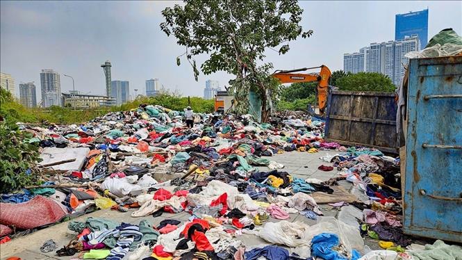 Lượng lớn quần áo cũ được tập kết tại khu vực ngõ 252 Mỹ Đình, phường Từ Liêm (Hà Nội), gây mất mỹ quan đô thị và tiềm ẩn nguy cơ ô nhiễm môi trường. Ảnh: Trung Nguyên - TTXVN.