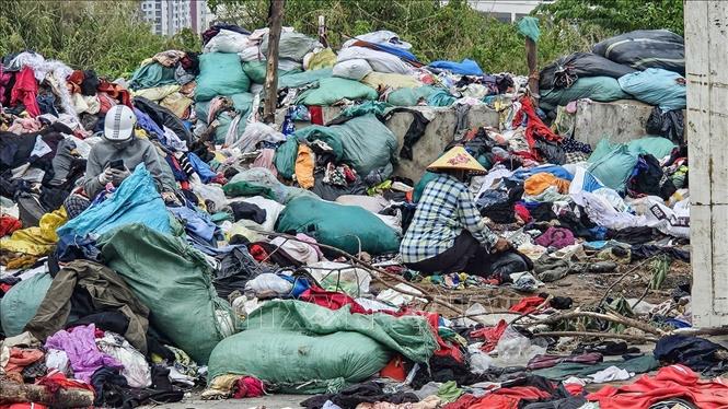 Quần áo cũ chất thành đống lớn tại khu đất thuộc dự án đường nối Phạm Hùng – Lê Đức Thọ, phường Từ Liêm (Hà Nội). Ảnh: Trung Nguyên - TTXVN.