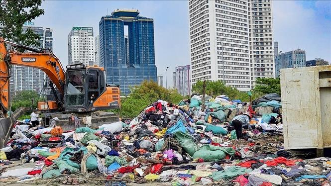 Quần áo cũ bị đổ bỏ ngổn ngang tại khu vực ngõ 252 Mỹ Đình, phường Từ Liêm (Hà Nội). Ảnh: Trung Nguyên - TTXVN.
