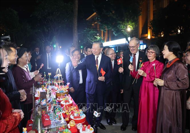 Tổng Bí thư, Chủ tịch nước Tô Lâm và Phu nhân cùng Tổng thống Thụy Sĩ Guy Parmelin và Phu nhân tham quan sạp tò he của những nghệ nhân làng Xuân La - nét văn hóa dân gian độc đáo trên phố đi bộ hồ Hoàn Kiếm. Ảnh: Thống Nhất - TTXVN