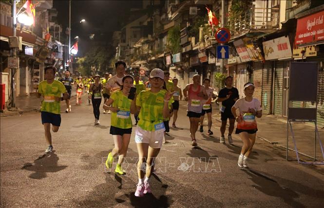 Các runner chạy trên phố Hàng Đào yên bình trong đêm. Ảnh: Quốc Khánh - TTXVN